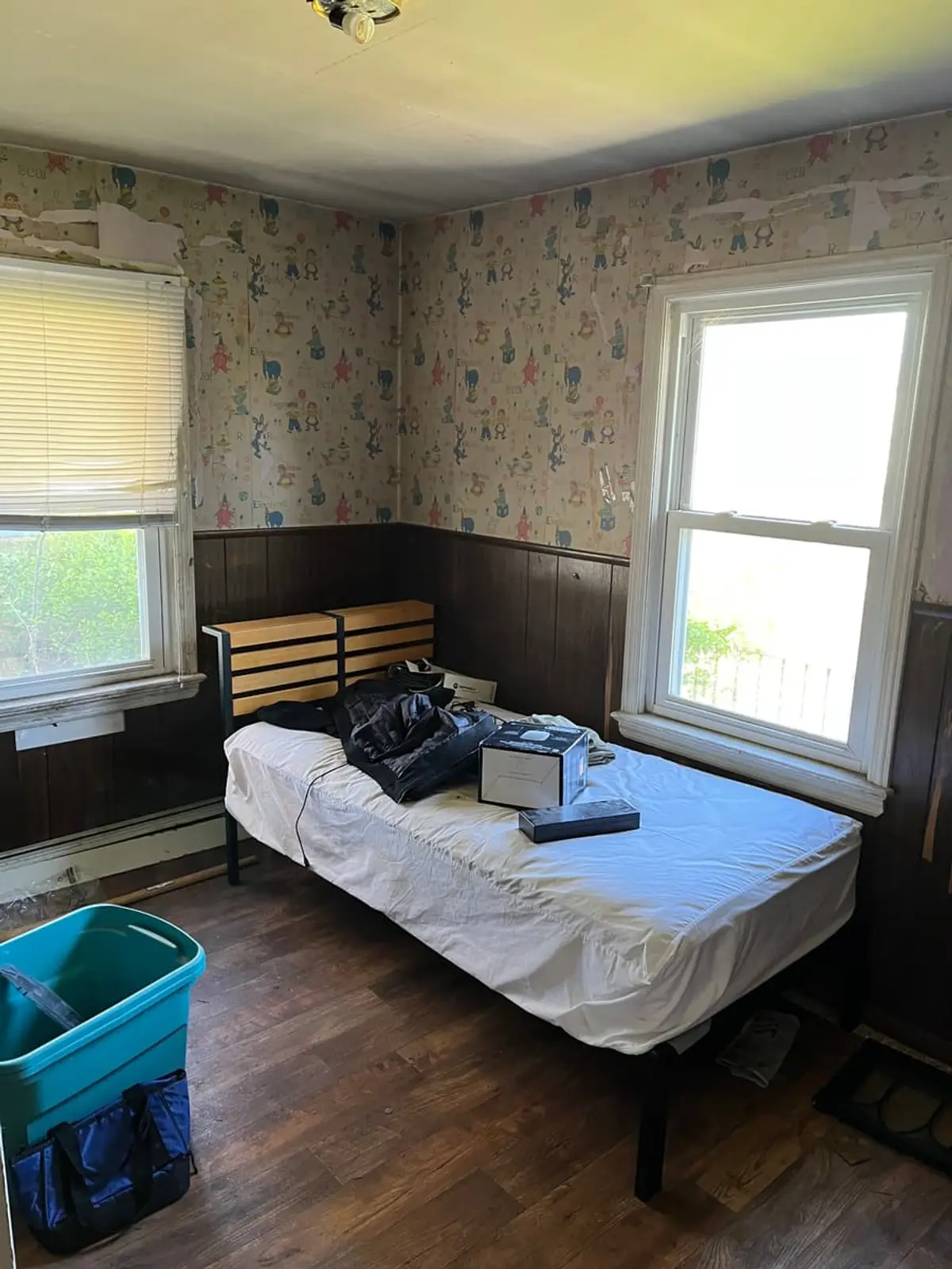 Selling an inherited house in Lindenhurst: bedroom with faded floral wallpaper and dark wainscoting