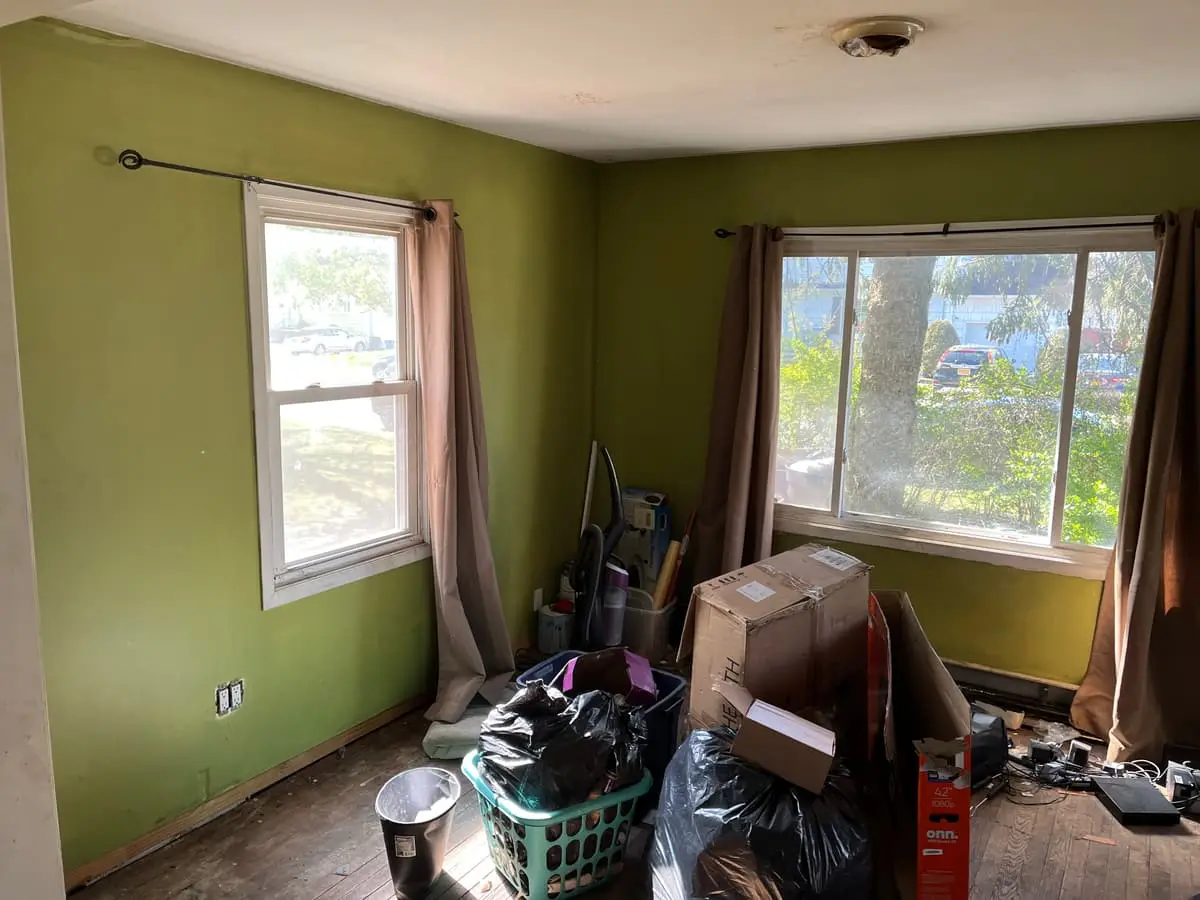 Selling without a realtor in Lindenhurst: green living room with bags and boxes piled by the window