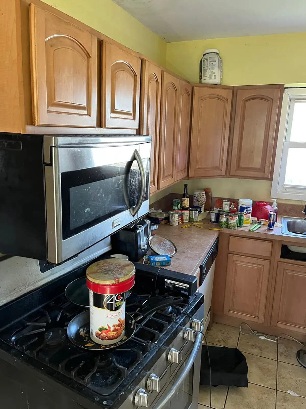 Selling a house during a divorce in Lindenhurst: occupied kitchen with oak cabinets and a gas range