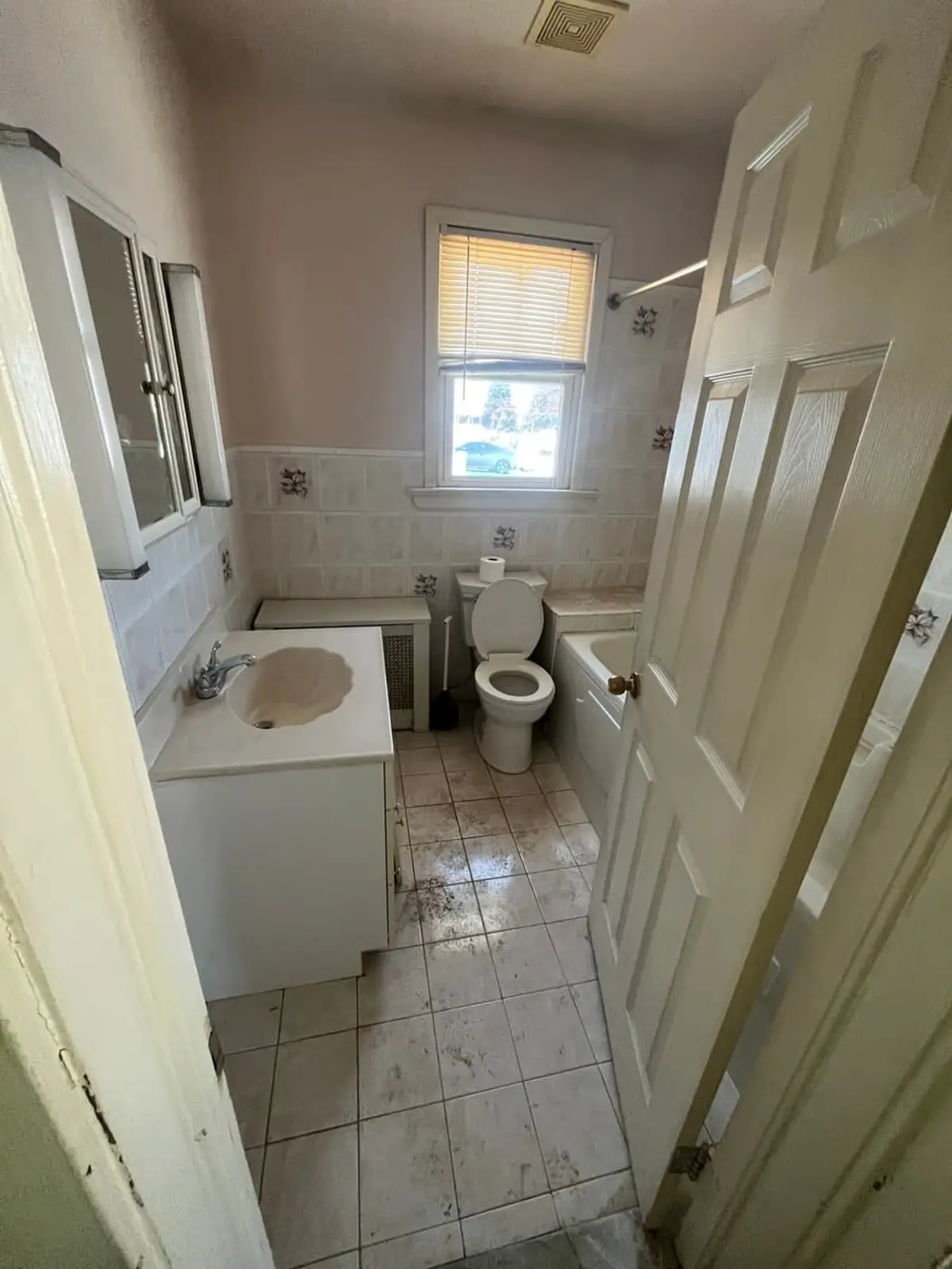 Downsizing or retiring in Lindenhurst: small dated bathroom with white tile and a narrow vanity